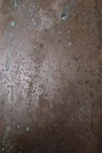 Die Nahaufnahme zeigt eine kunstvolle Wand mit ATHOS-PatinaEchtmetall-Spachtel, ideal für kreative Wandgestaltung.