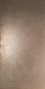 Eine elegante, bronzefarbene Wandgestaltung mit metallischem Glanz verleiht dem Raum ein luxuriöses Ambiente.