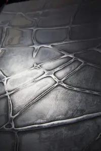 Die stilvolle Wandgestaltung zeigt eine metallische Textur mit Bronze- und Silberakzenten von Einhornwerke.