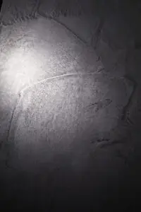 Die Wand zeigt eine elegante Textur in Eisen gespachtelt von Einhornwerke, ideal für kreative Wandgestaltung im Wohnzimmer.