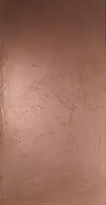 Eine stilvolle Wand zeigt eine Kupferstruktur mit ATHOS-Kupfer-gespachteltEchtmetall-Spachtel von Einhornwerke.