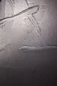 Eine Wand zeigt eine elegante Silberbronze-Oberfläche, die mit ATHOS-Echtmetall von Einhornwerke kunstvoll gespachtelt wurde.