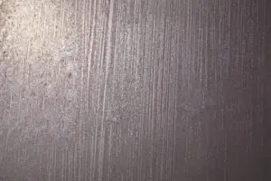 Diese Nahaufnahme zeigt eine Wand mit eleganter ATHOS-Silberbronze-Textur, ideal für kreative Wohnzimmer-Wandgestaltung.