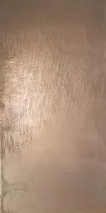 Eine edle Wand aus Zinnbronze zeigt feine Strukturen und verleiht dem Wohnzimmer eine luxuriöse Wandgestaltung.