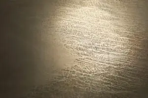 Die Wand zeigt eine elegante Zinnbronze-Struktur, ideal für kreative Wandgestaltung im Wohnzimmer von Einhornwerke.