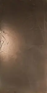 Eine Wand im Wohnzimmer zeigt eine stilvolle ATHOS-Zinnbronze-Oberfläche von Einhornwerke für kreative Wandgestaltung.