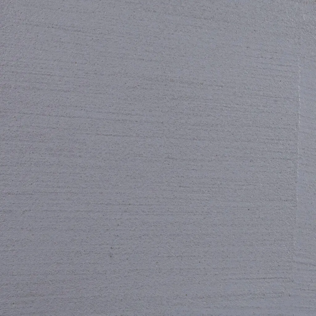 Eine graue Wand zeigt die feine Struktur des HERKLULES-1908 Streichputzes für kreative Wandgestaltung.