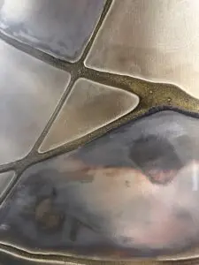 Eine stilvolle Wandfläche zeigt metallische Spachteltechnik mit flüssigem Metall, ideal für kreative Möbelgestaltung. Rezept: Unikat