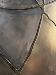 Eine stilvolle Wandfläche zeigt metallische Spachteltechnik mit flüssigem Metall, ideal für kreative Möbelgestaltung. Rezept: Unikat