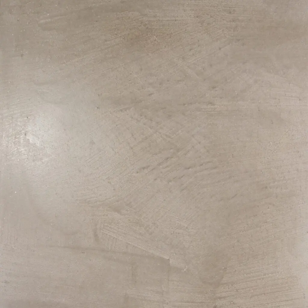 Eine glatte Wandfläche in Creme zeigt den eleganten MARMOREA Kalkputz, ideal für kreative Wandgestaltung im Wohnzimmer.