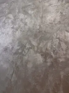 Eine detailreiche MONROE-Wandbeschichtung mit metallischem Glanz verleiht dem Wohnzimmer eine elegante Wandgestaltung.