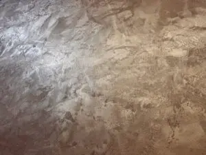 Ein eleganter MONROE-Effekt auf einer Wohnzimmerwand zeigt eine metallische Glanzbeschichtung von Einhornwerke.