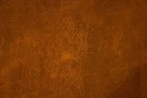 Eine detailreiche Rostspachtel-Wand aus der Einhornwerke Kollektion zeigt kreative Wandgestaltung im Wohnzimmer.