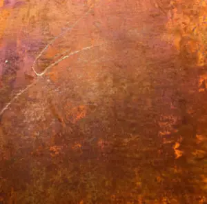 Eine Wand mit magnetischer Echtrost-Beschichtung zeigt eine kunstvolle Textur, ideal für kreative Wandgestaltung im Wohnzimmer.