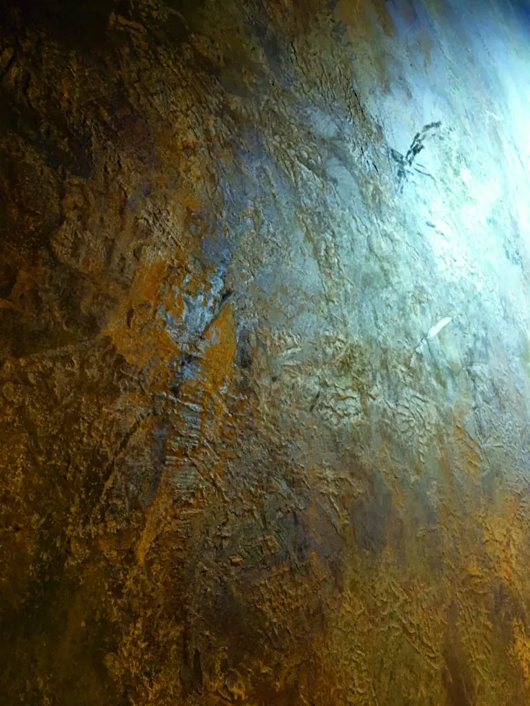 Die Wand zeigt eine beeindruckende Rostoptik mit magnetischer Beschichtung, ideal für kreative Wandgestaltung im Wohnzimmer.