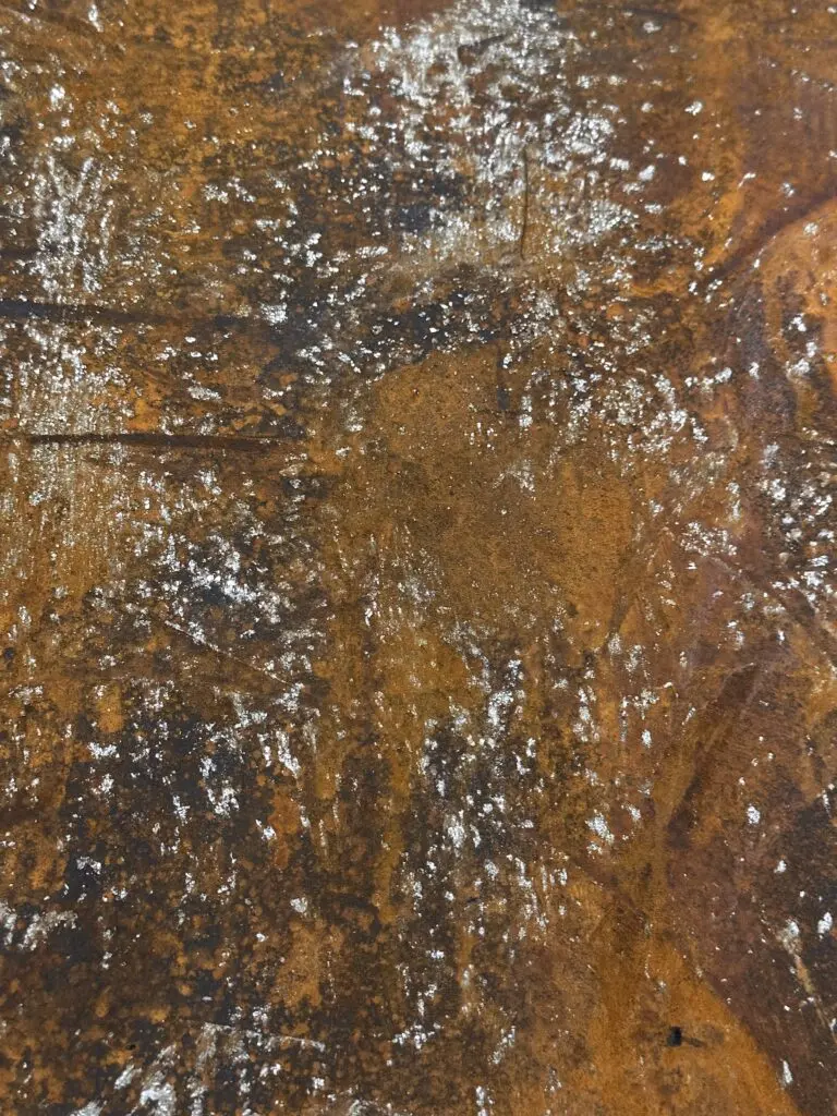 Rostfarbene Textur mit magnetischer Beschichtung verleiht der Wandgestaltung im Wohnzimmer ein industrielles Flair.