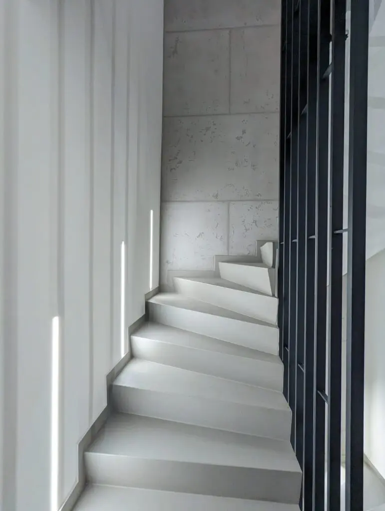 Ein modern gestaltetes Treppenhaus mit fugenlos gespachtelten Betonoptik-Wänden von Maler-Maiwald.