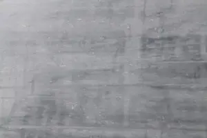 Eine graue Wand mit glatter Oberflächenstruktur zeigt die kreative Wandgestaltung mit STUCCORINO Kalkputz.