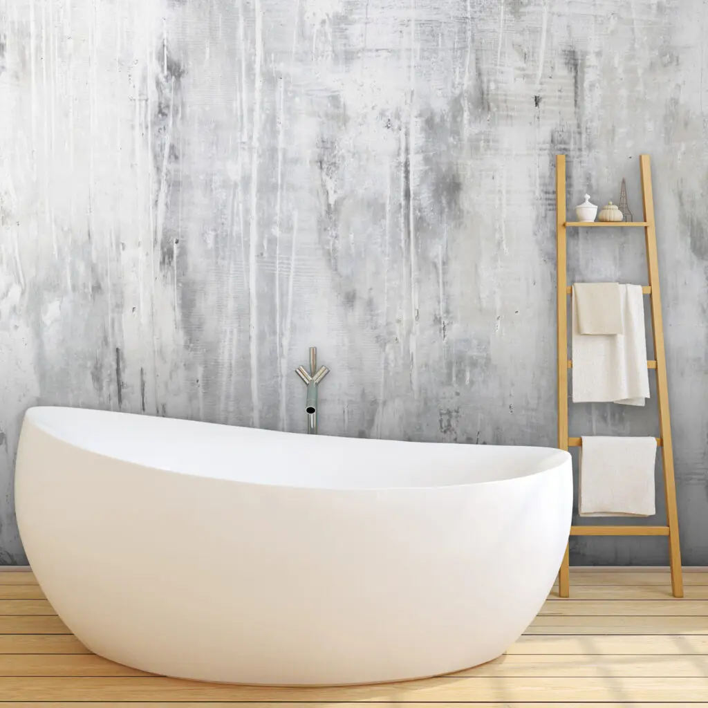 Freistehende Badewanne vor grauweißer STUCCORINO Avantgarde Wand mit senkrechten Schlieren und Holzleiter