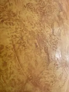 Detailreiche Kalkputz-Oberfläche in warmen Tönen, ideal für stilvolle Wandgestaltung in modernen Wohnräumen.