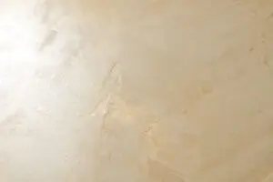 Die Oberfläche zeigt den schimmernden Effekt des gelbgoldenen Kalkputzes von Oberflaeche-STUCCORINO für stilvolle Wandgestaltung.