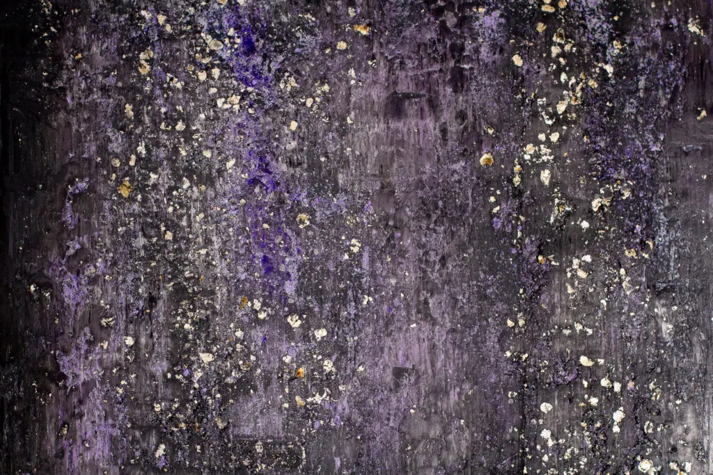 Die Wandgestaltung zeigt eine fugenlose, glitzernde Oberfläche in Lila mit Goldglimmer, ideal für ein modernes Wohnzimmer.