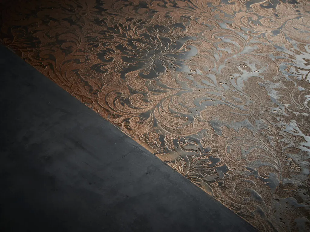 Eine detailreiche Bronze-Oberfläche mit STUCCORINO®-Struktur verleiht der Wandgestaltung im Wohnzimmer Eleganz.