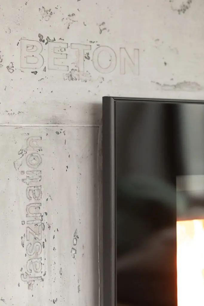 STUCCORINO Wand in Betonoptik mit eingeprägten Schriftzügen Beton und Faszination neben schwarzem Rahmen