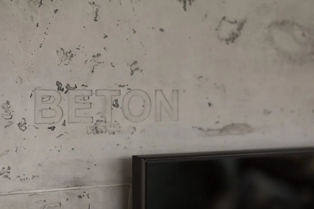 Die Betonwand im Wohnzimmer zeigt moderne Wandgestaltung mit Oberflaeche STUCCORINO Betonoptik.