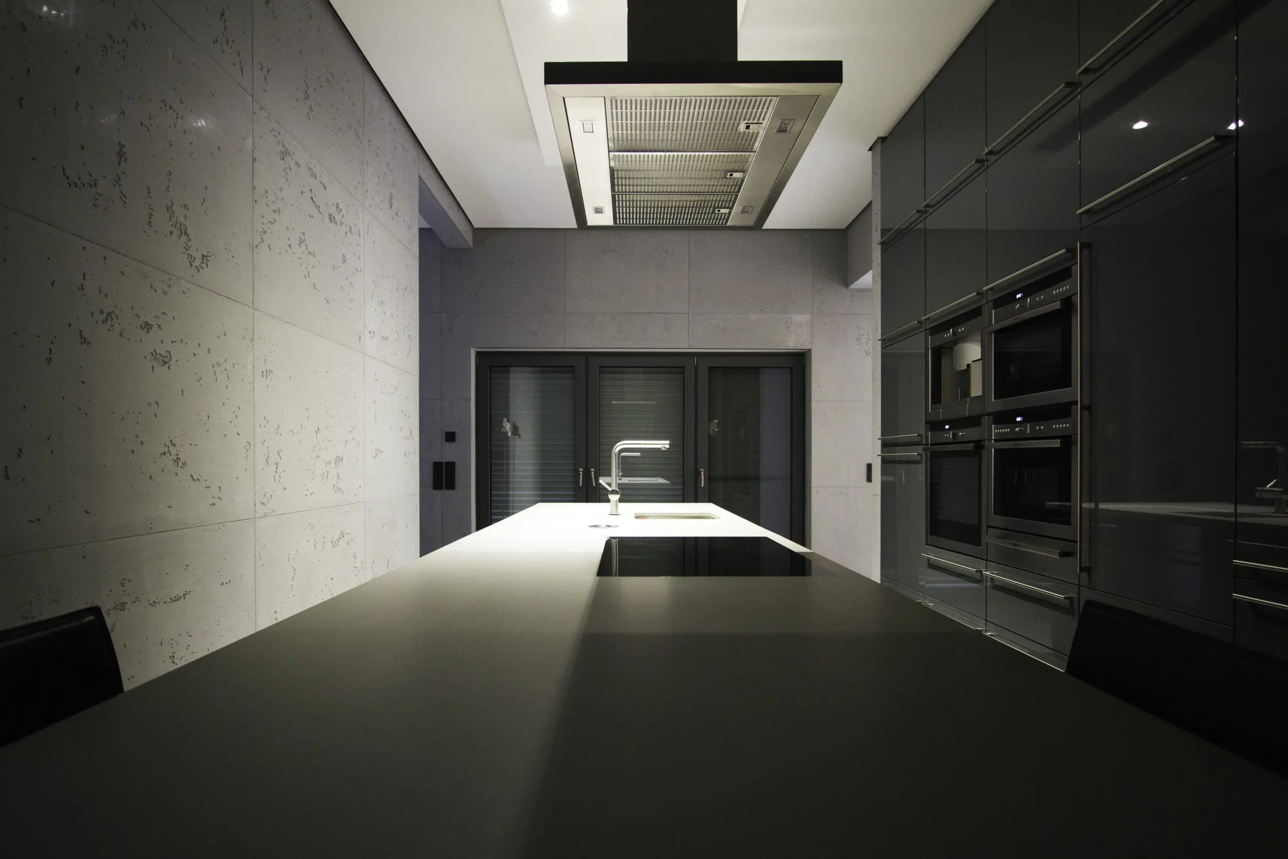 Ein modernes Wohnzimmer zeigt elegante Wandgestaltung in Betonoptik und stilvollem Interieur.