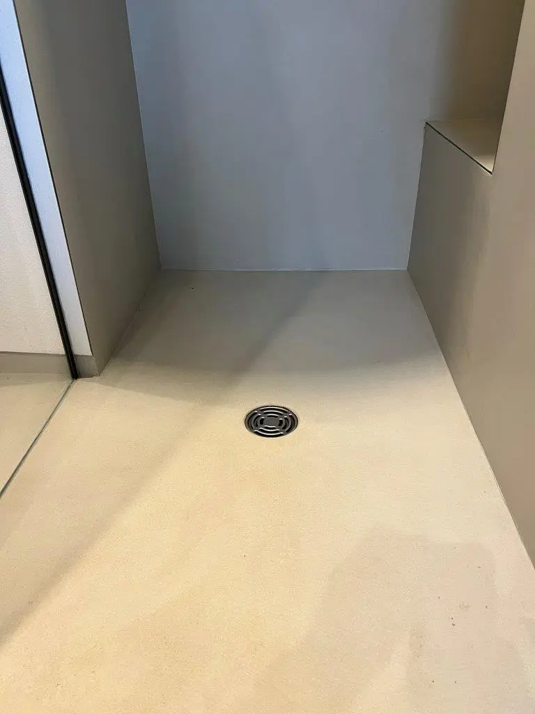 Eine moderne Dusche mit minimalistischer Wandgestaltung und einem glatten Boden aus hochwertigem Streichputz.