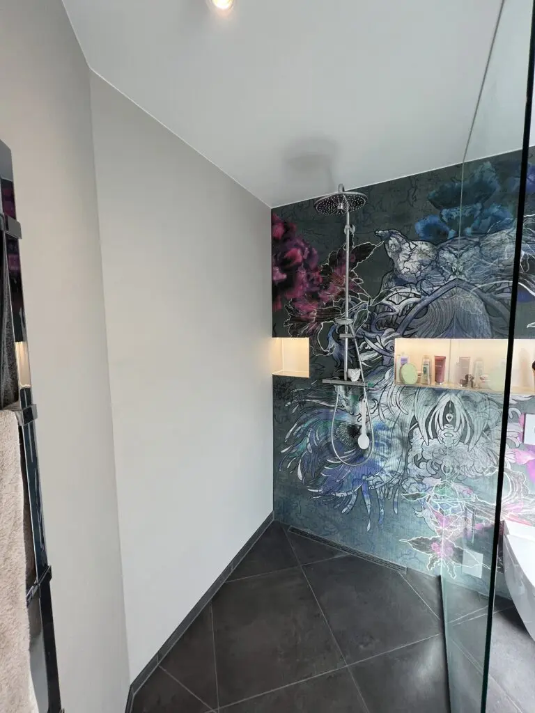 Das Badezimmer zeigt eine fugenlose Wandgestaltung mit einem kunstvollen Einhornmotiv von Einhornwerke.