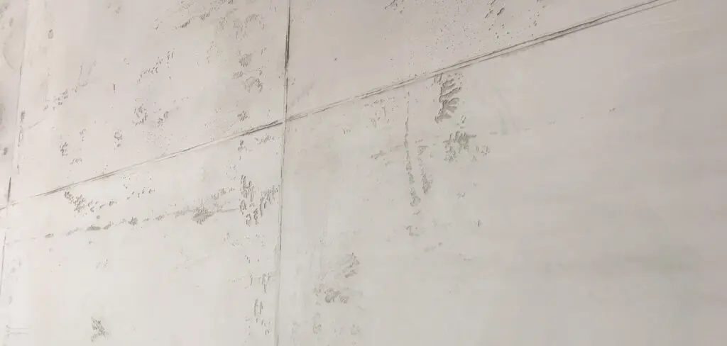 Eine Nahaufnahme zeigt eine Betonoptik-Wand in hellgrau, ideal für moderne Wandgestaltung im Wohnzimmer.