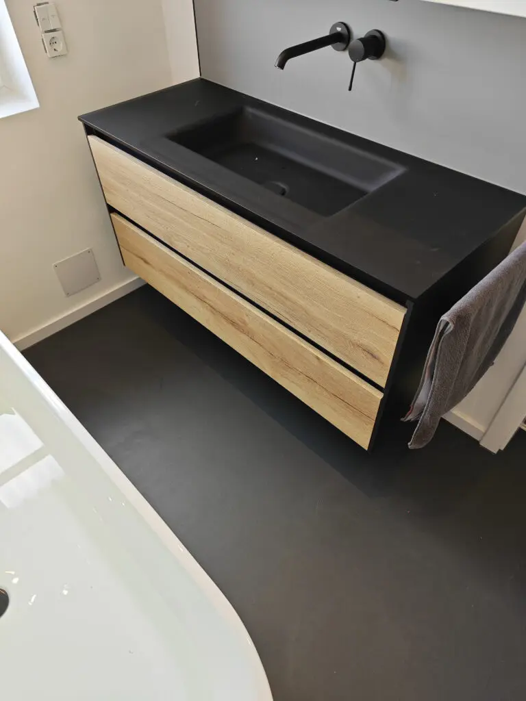 Ein stilvolles Badezimmer mit modernem Waschbecken und Microzement-Boden vom Hersteller Einhorn Werke.