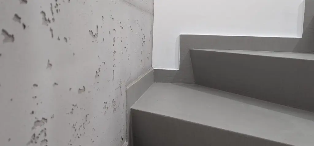Ein modernes Treppenhaus zeigt eine stilvolle Wandgestaltung in Betonoptik von Einhornwerke.