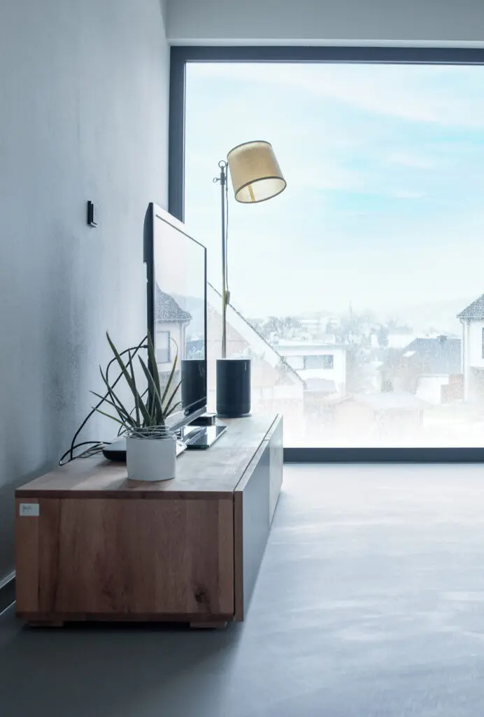 Ein modernes Wohnzimmer mit stilvoller Wandgestaltung und Bodenbelägen in Betonoptik von Einhornwerke.