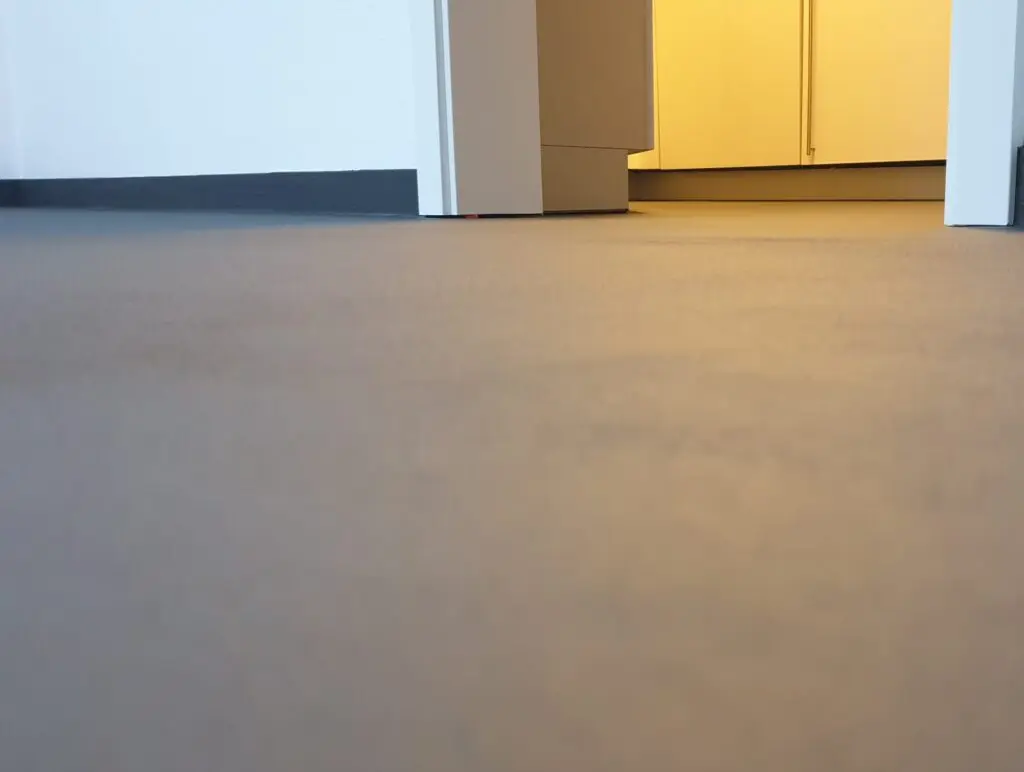 Grauer fugenloser Boden in Bodenperspektive mit Blick auf Türöffnung und Einbauschrank