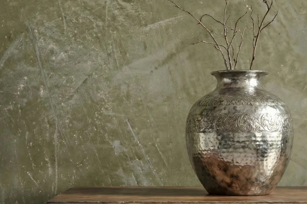 Ein stilvolles Wohnzimmer mit STUCCORINO-Kalkputz-Wand und eleganter Vase auf einem Holztisch. | © Einhornwerke