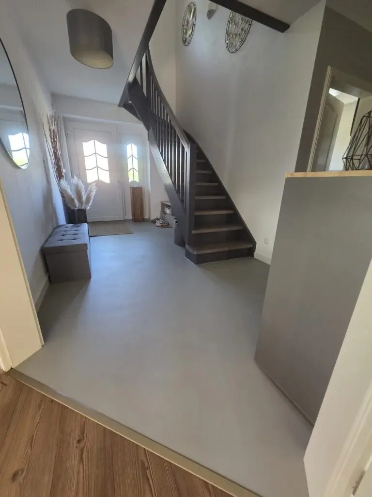 Diele mit hellgrauem fugenlosem Boden, Sitzbank und Treppe, Übergang zu Holzdielen