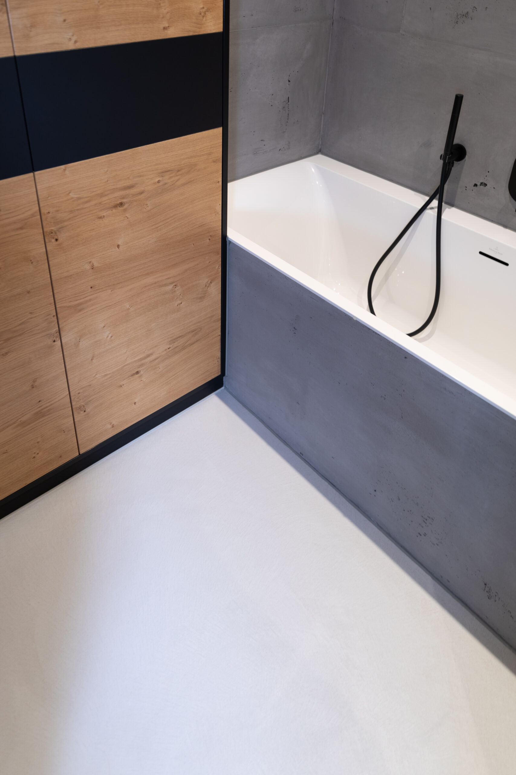 Ein modernes Badezimmer mit fugenlosem Design und stilvoller Wandgestaltung in Betonoptik ergänzt die Holzverkleidung.