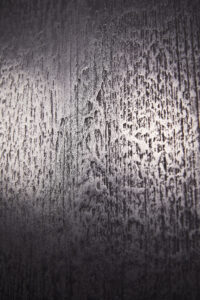 Eine detailreiche Wand im Wohnzimmer zeigt eindrucksvolle Metallisierung mit ATHOS-Aluminium von Einhornwerke.