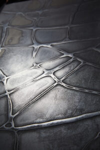 Die stilvolle Wandgestaltung zeigt eine metallische Textur mit Bronze- und Silberakzenten von Einhornwerke.