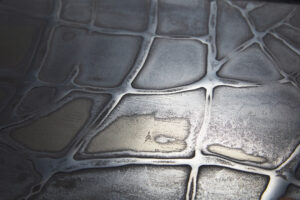 Diese Nahaufnahme zeigt eine kunstvolle Metallisierung mit flüssigem Metall für kreative Wandgestaltung von Einhornwerke.