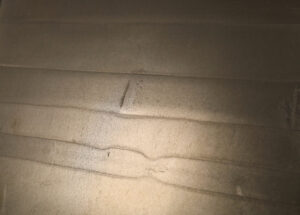 Die Wand zeigt eine elegante Metallisierung mit ATHOS-Messing und verleiht dem Raum eine stilvolle Wandgestaltung.