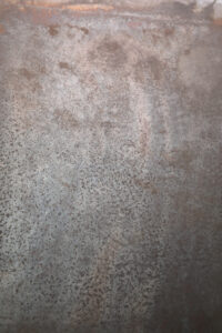 Eine Wand im Wohnzimmer zeigt eine elegante, metallische Struktur mit ATHOS-Silberbronze für kreative Wandgestaltung.