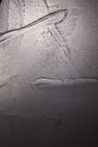 Eine Wand zeigt eine elegante Silberbronze-Oberfläche, die mit ATHOS-Echtmetall von Einhornwerke kunstvoll gespachtelt wurde.