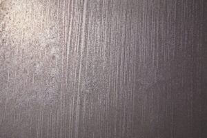 Diese Nahaufnahme zeigt eine Wand mit eleganter ATHOS-Silberbronze-Textur, ideal für kreative Wohnzimmer-Wandgestaltung.