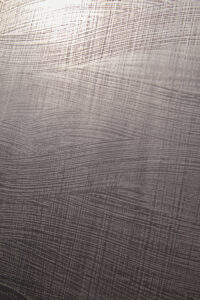 Die Wand zeigt eine detailreiche Struktur in Metalloptik, ideal für kreative Wandgestaltung im Wohnzimmer von Einhornwerke.