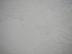 Eine strukturierte Wandoberfläche zeigt die elegante Textur von Streichputz, ideal für kreative Wandgestaltung im Wohnzimmer.
