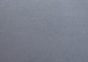 Eine graue Wandoberfläche mit feiner Textur zeigt das Ergebnis von HERKULES-MX Streichputz für kreative Wandgestaltung.